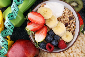 muesli with dairy and fruit, healthy lifestyle. bowl of cereal, fruit and dumbbell