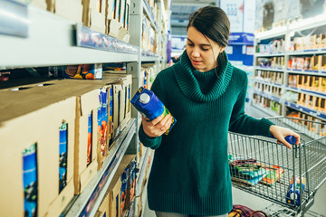 woman in store read ingredients of juice. grocery shopping. copy