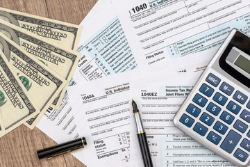 1040 form with dollar, pen and calculator
