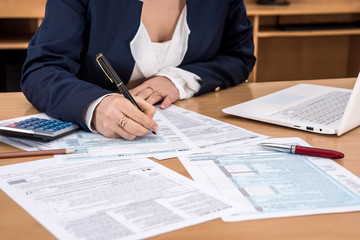 business lady fills the 1040 tax form .