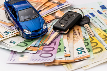 Toy automobile and real keys on euro banknote background