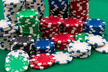 many poker chips isolated on a green background