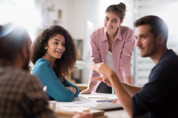 meeting office. A young woman presents her project to her group