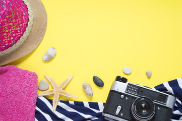 Yello travel concept for see or beach. Old vintage camera, hat, seestar, towel, sundress with stripes. Flat layout summer.