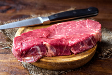 uncooked horse meat steaks on rustic wooden board