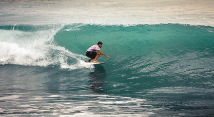 Surfer on Blue Ocean Wave, Bali, Indonesia. Riding in tube.
