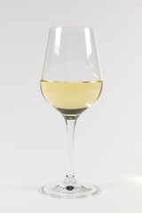 Halb gefülltes Glas Weißwein auf weißem Hintergrund