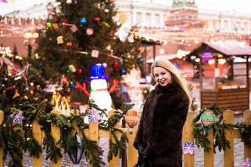 Portrait in full growth, Russian beautiful woman in a mink coat on the Red Square in Moscow in Christmas time