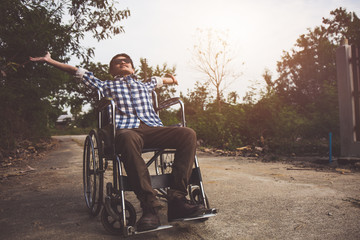 Young man outdoor with wheelchair on road.