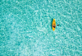 Frau im Kajak paddelt über das türkise Wasser der Malediven © moofushi