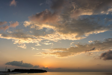 Tropischer Sonnenuntergang mit bewölktem Himmel