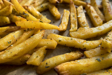 Appetizing fried potatoes located on paper. Close-up.