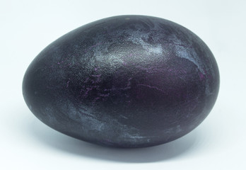 Theme Easter. Close-up of a duck egg stained in dark shades of violet.
