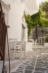 Fototapeta na wymiar Outdoor part of taverna on the streets of Naxos town at Naxos island in Greece