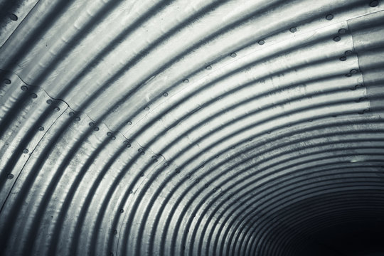 Shiny corrugated steel wall, tunnel pattern