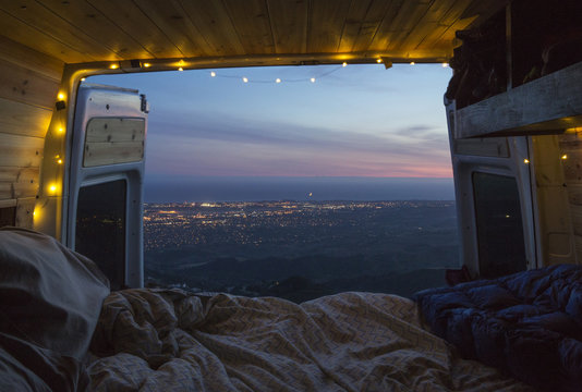 Scenic view of landscape against sky seen from illuminated motor home during sunset