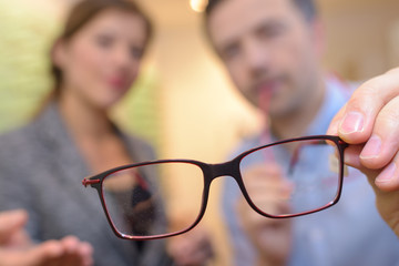 thin wire framed spectacles close focus in optician hands