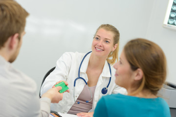 patient handing card to a young female doctor
