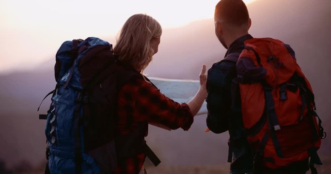 Mixed age hikers on mountain choosing trail on map