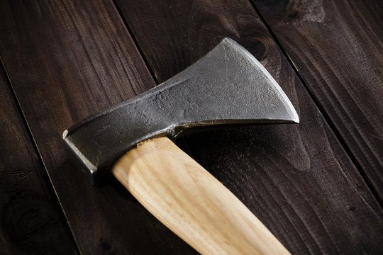 Closeup lumberjack axe on dark wooden background