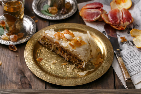 Phyllo pastry chicken pie on copper plate with tea, close view