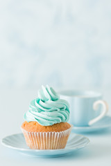 Blue pastel vertical banner with decorated cupcakes, cup of coffe with milk.