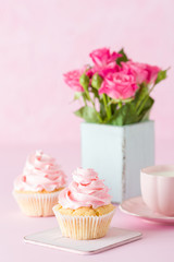 Pink pastel vertical banner with decorated cupcakes, cup of coffe with milk and bouquet of pink roses.