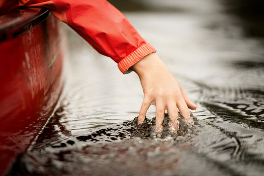 Cropped Hand Of Girl Touching Water While Traveling In Boat On River