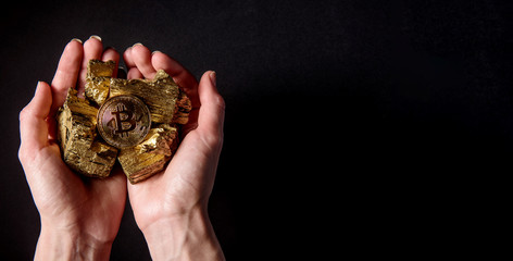 in the hands of pieces of gold and bitcoin. concept of profitable mining