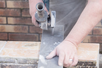tiler cutting a tile with a grinder