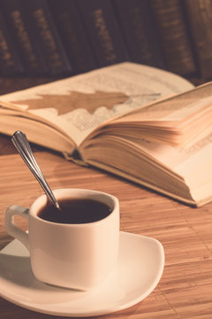 A cup of coffee and an open book on the table