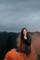 Teen girl with orange smoke background laughing