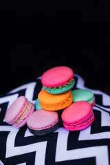 Fresh multicolored macaroon cookies on a black and white background