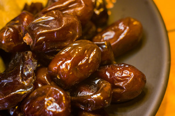 dried dates in a ceramic plate on a wooden table