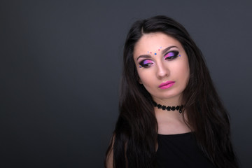 Fototapeta premium Close up face. Young arabic woman in black sexy dress, isolated on gray background