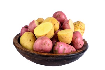 Raw potatoes in wooden bowl. Isolated close up food photo.