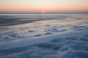 Frozen sea on sunset. Beautiful natural seascape on winter time. Endless ice to horizon. Ice surface for product placing.