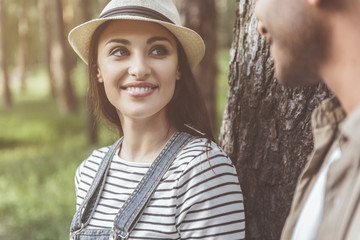 Couple standing in park. Young girl looking at man with love and laughing
