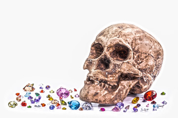 you can not take anything with you when you die.head skull on diamonds beside orb in white background.