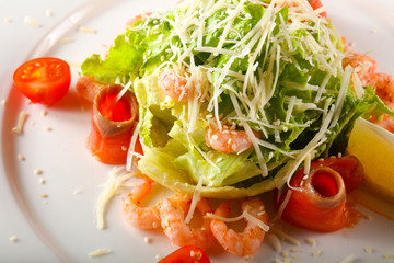 Caesar salad with shrimps and salmon