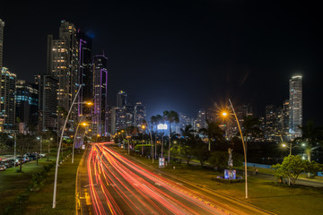 Fototapeta na wymiar city at night, street traffic with modern skyscraper skyline