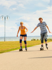 Young couple on roller skates riding outdoors