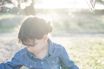 little girl posing in spring almond blossom