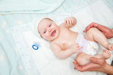 Dad puts a diaper on the baby.