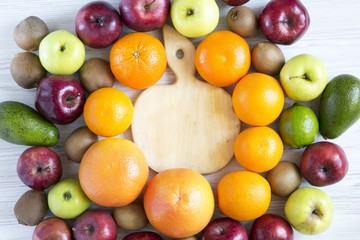 Set of raw fruits with wooden board on white wooden background. Top view. Flat lay.