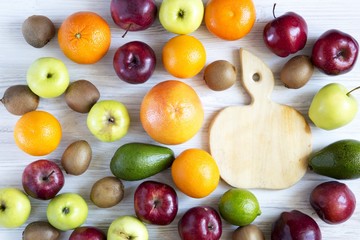 Set of raw fruits with wooden board on white wooden background. Top view. Flat lay.