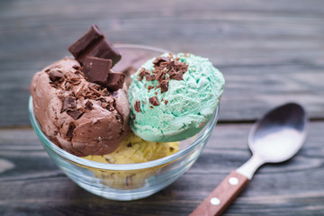 Set of various flavored ice cream scoops with chocolate crumbs served in glass bowl, close up. Delicious summer sweets, food background