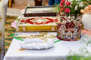 Altar in the Christian temple. The decorated cross, icon, Bible and crown and wedding rings lie on altar. Christian traditions in Wedding day 