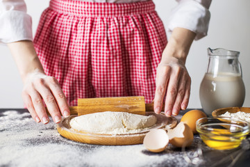 Obraz na płótnie Canvas Making dough by female hands at bakery