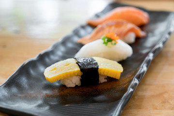 Close up of japanese cuisines nigiri sushi set on black plate served in japanese food restaurant.